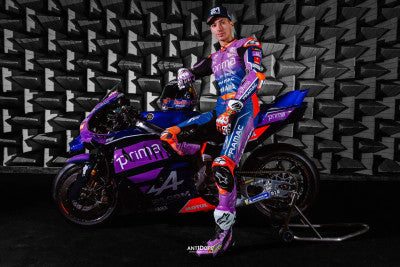 Toprak Razgatlioglu standing with the Prima Pramac Yamaha MotoGP bike